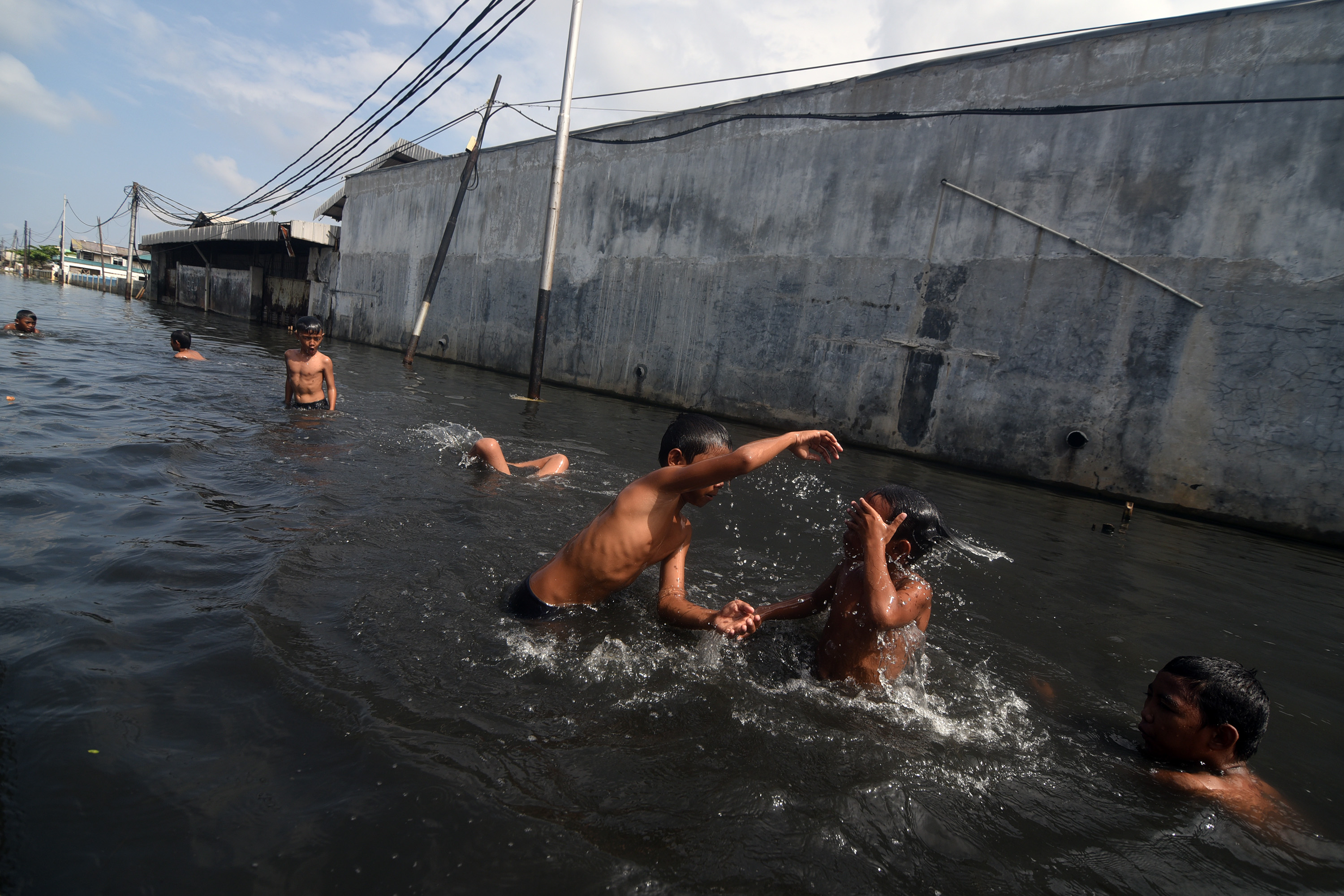 Sejumlah anak bermain di genangan air ketika air laut pasang (rob) melanda kawasan Muara Baru, Jakarta Utara, Senin (16/2)
