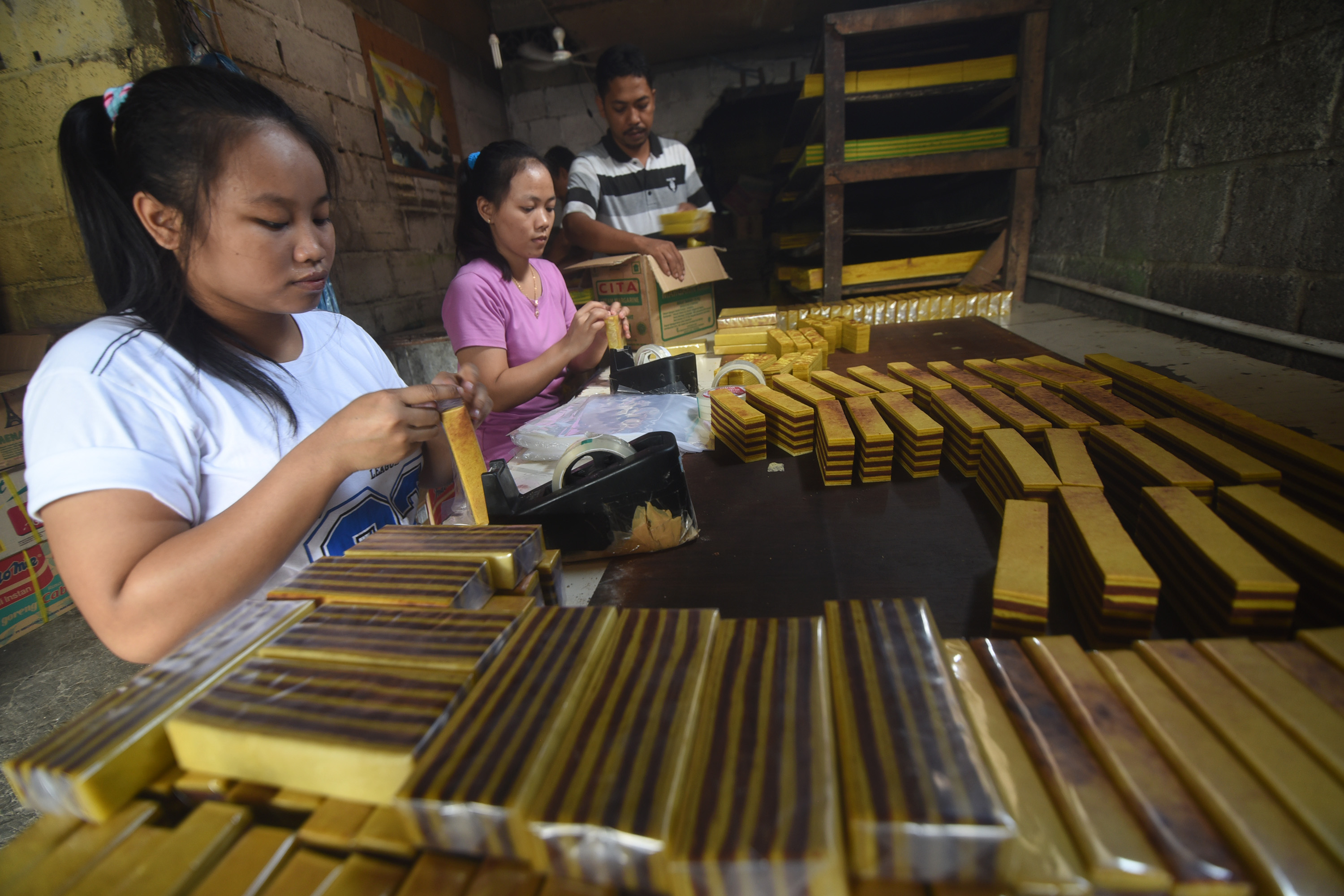 Pekerja mengemas kue lapis di sebuah industri rumahan, Jakarta, Selasa (3/3).