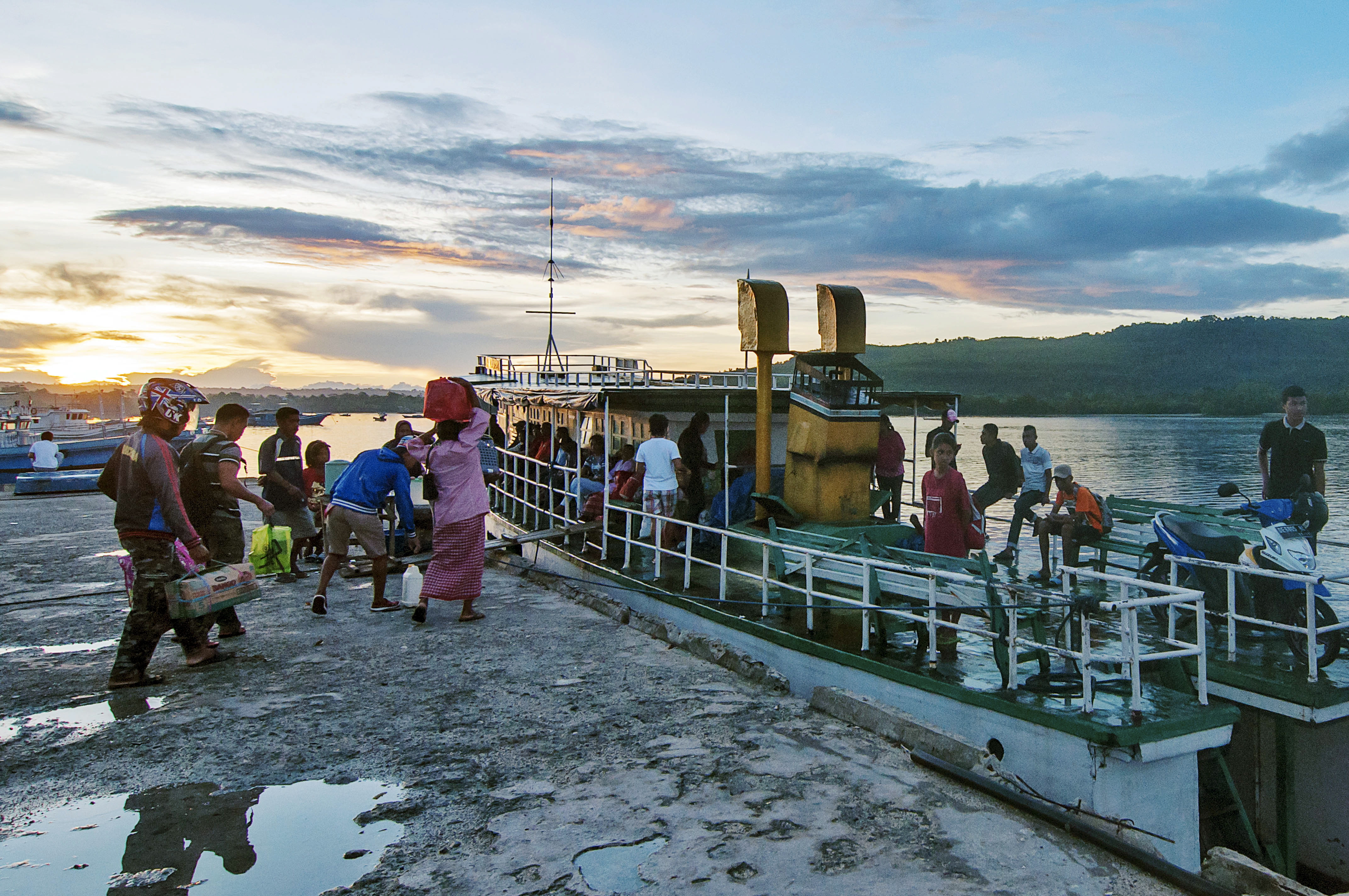 Sejumlah warga menaiki kapal motor yang akan berangkat dari Pulau Saparua ke Pulau Ambon, di Pelabuhan Desa Haria, Kecamatan Pulau Saparua, Kabupaten Maluku Tengah, Maluku, Kamis (16/4)