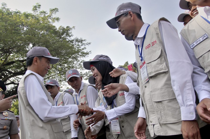 Presiden Joko Widodo (kiri) menyalami Guru Garis Depan (GGD) usai upacara pelepasan di halaman Istana Negara, Jakarta, Senin (25/5).