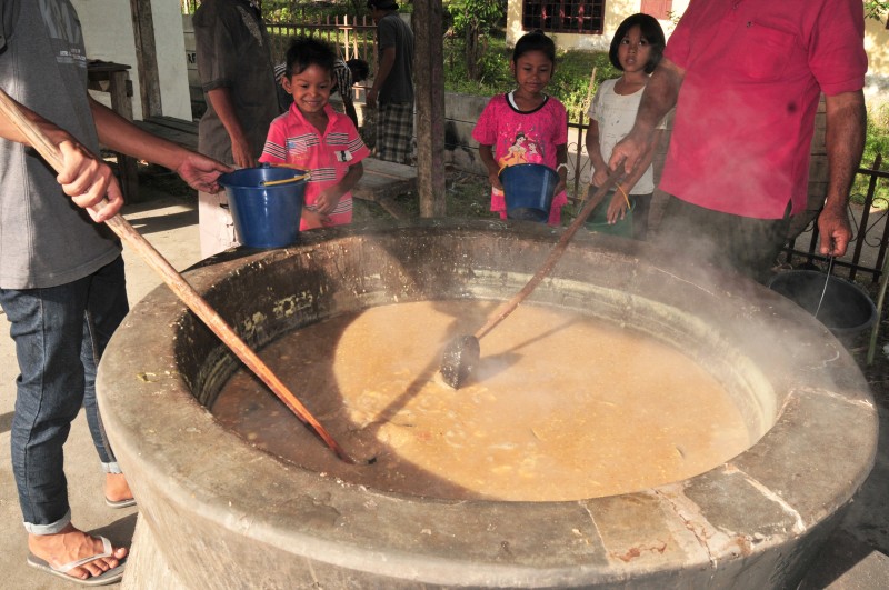 Warga membagikan makanan bubur khas Aceh, Ie Bu Peudah atau air nasi pedas di Meunasah Kuta Baro, Kabupaten Aceh Besar, Aceh, Rabu (24/6).