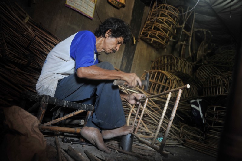 Perajin merangkai rotan untuk dijadikan keranjang parsel di sentra perajin rotan di kawasan 3 Ilir Palembang, Sumsel, Rabu (24/6).