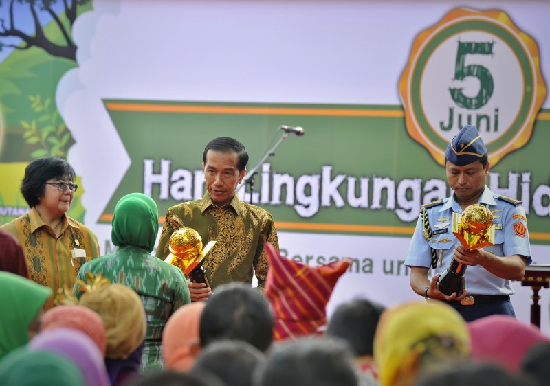 Presiden Joko Widodo (tengah) didampingi Menteri Lingkungan Hidup dan Kehuatanan Siti Nurbaya (kiri) menyerahkan penghargaan Adiwiyata Mandiri saat peringatan Hari Lingkungan Hidup Se-Dunia 2015 di Istana Bogor, Jumat (5/6).