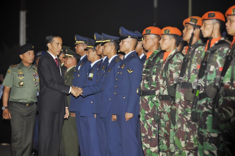 Presiden Joko Widodo (kedua kiri) didampingi Panglima TNI Jenderal Moeldoko (kiri) menyalami kerabat korban dan Prajurit TNI AU usai memimpin upacara penghormatan terakhir korban kecelakaan Hercules C-130 di Lanud Halim Perdana Kusuma, Jakarta, Rabu (1/7)