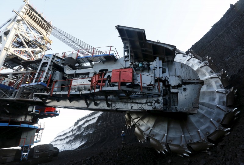 Master Suprun uses portable radio set as he stands near rotary dredge which works on coal face of Borodinsky opencast colliery near Siberian town of Borodino