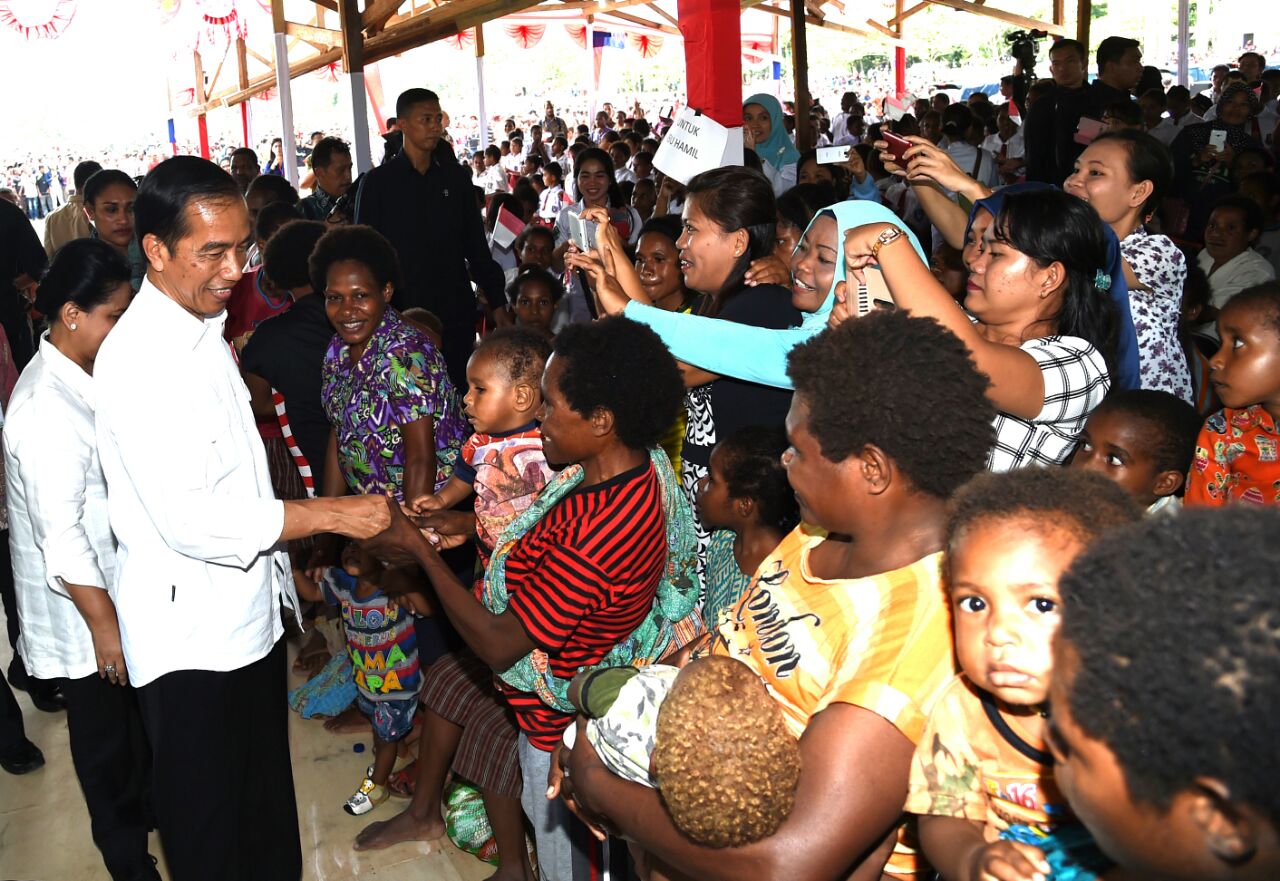 Presiden Joko Widodo memberikan biskuit khusus sebagai makanan tambahan gizi bagi ibu hamil dan para balita serta anak-anak di Kabupaten Yahukimo, Papua Ibu Papua, Perempuan Indonesia yang tangguh