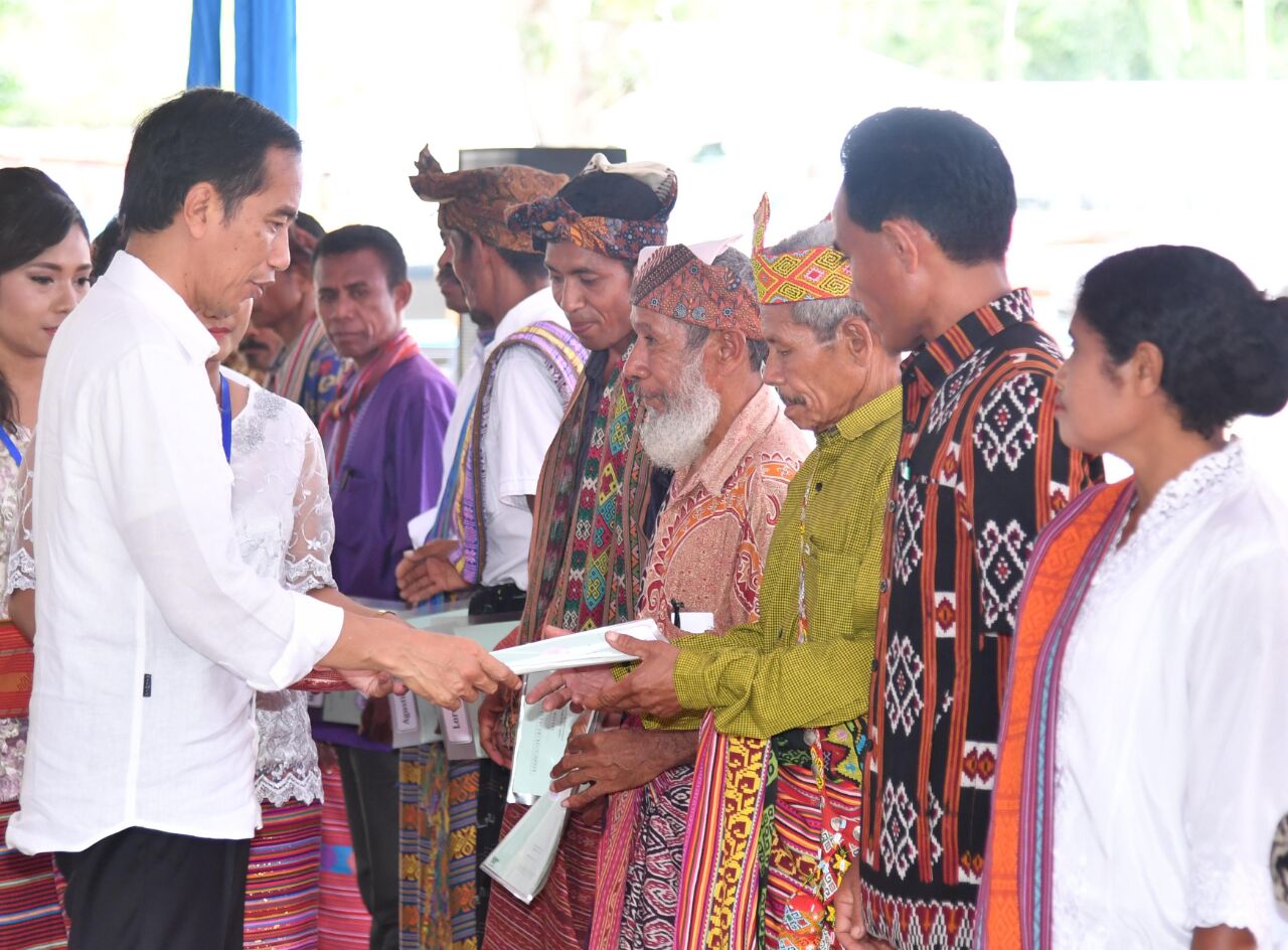 Presiden Joko Widodo menyerahkan sertifikat tanah program strategis tahun 2016 kepada pemilik sertifikat tanah di Lapangan Sepakbola Desa Silawan, NTT, Rabu 28 Desember 2016