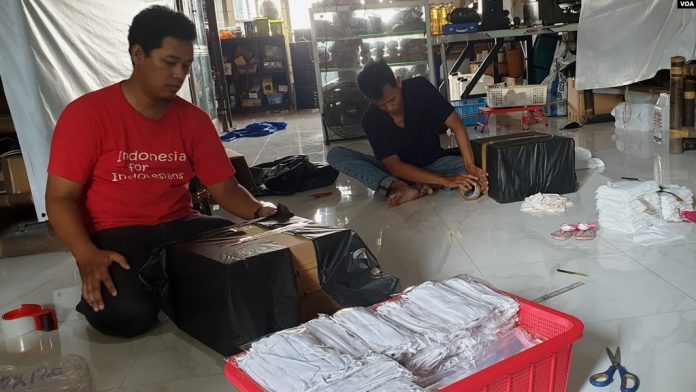 Relawan Jatim for Indonesia mengemas sejumlah bantuan untuk warga terdampak corona di berbagai daerah (Foto VOA Petrus Riski).