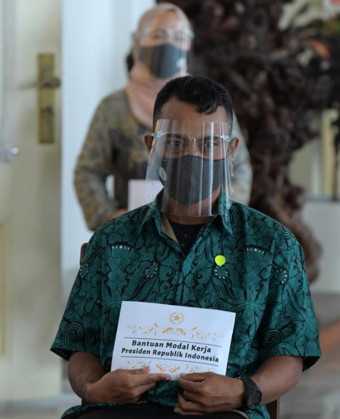Presiden Joko Widodo menyerahkan Bantuan Modal Kerja kepada para pelaku UMK di teras Istana Kepresidenan Bogor