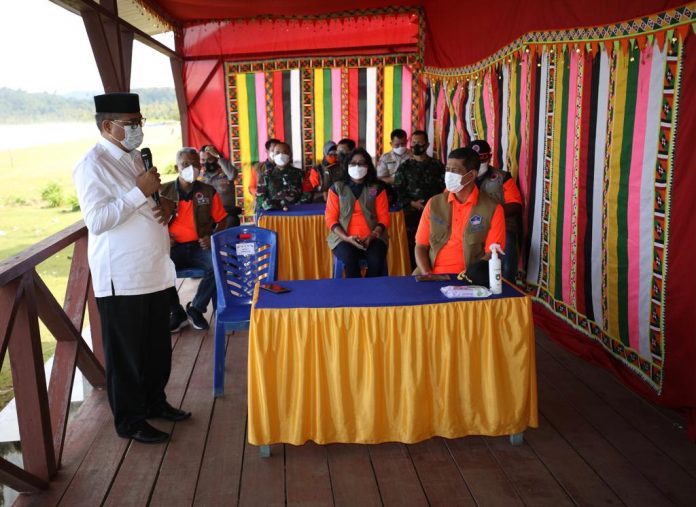 Kepala BNPB Letjen TNI Dr. (H.C.) Doni Monardo (kanan duduk) mendengarkan sambutan dari