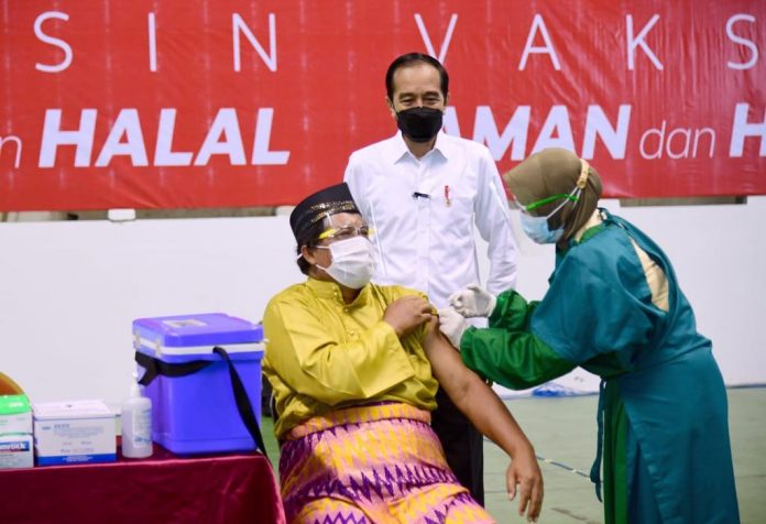 Presiden Joko Widodo meninjau pelaksanaan vaksinasi massal Covid-19 di Gelanggang Olahraga Remaja, Kecamatan Marpoyan Damai, Kota Pekanbaru