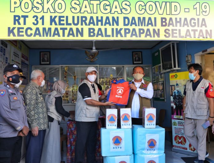 Ketua Satgas Penanganan Covid-19 Ganip Warsito menyerahkan bantuan secara simbolis kepada ketua RT 31 Kel Damai Bahagia Kec Balikpapan Selatan, Kalimantan Timur
