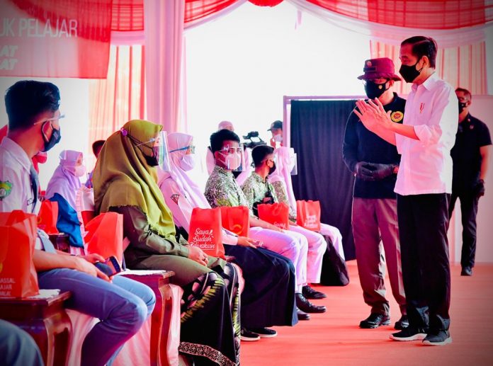 Presiden Joko Widodo meninjau vaksinasi Covid-19 untuk pelajar yang digelar di SMPN 3 Mejayan, Kabupaten Madiun, Provinsi Jawa Timur, pada Kamis, 19 Agustus 2021.
