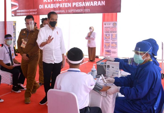 Presiden Joko Widodo meninjau kegiatan vaksinasi bagi 1.000 pelajardari berbagai sekolah yang digelar di SMP Negeri 1 Pesawaran, Provinsi Lampung