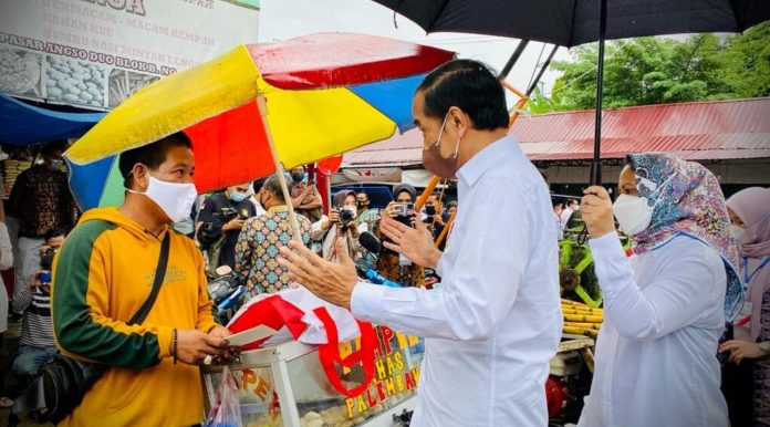 Presiden Joko Widodo memberikan Bantuan Langsung Tunai (BLT) Minyak Goreng kepada sejumlah pedagang kecil dan penerima di Pasar Rakyat Angso Duo Baru, Kota Jambi, Kamis, 7 April 2022.
