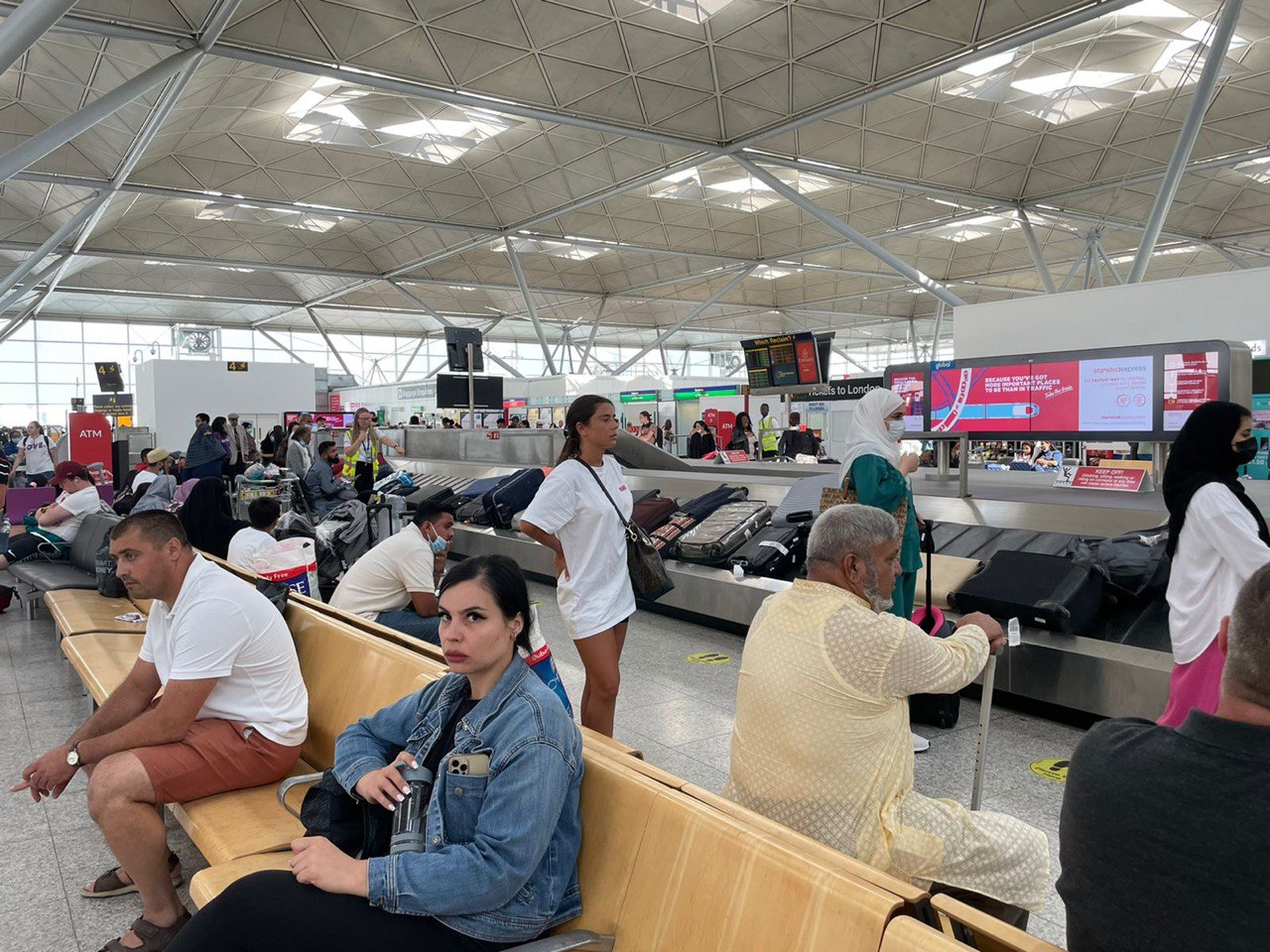 Orang – orang yang sedang mengambil bagasi di ruang kedatangan bandara Stansted London (Foto: Fanya/ vibizmedia)