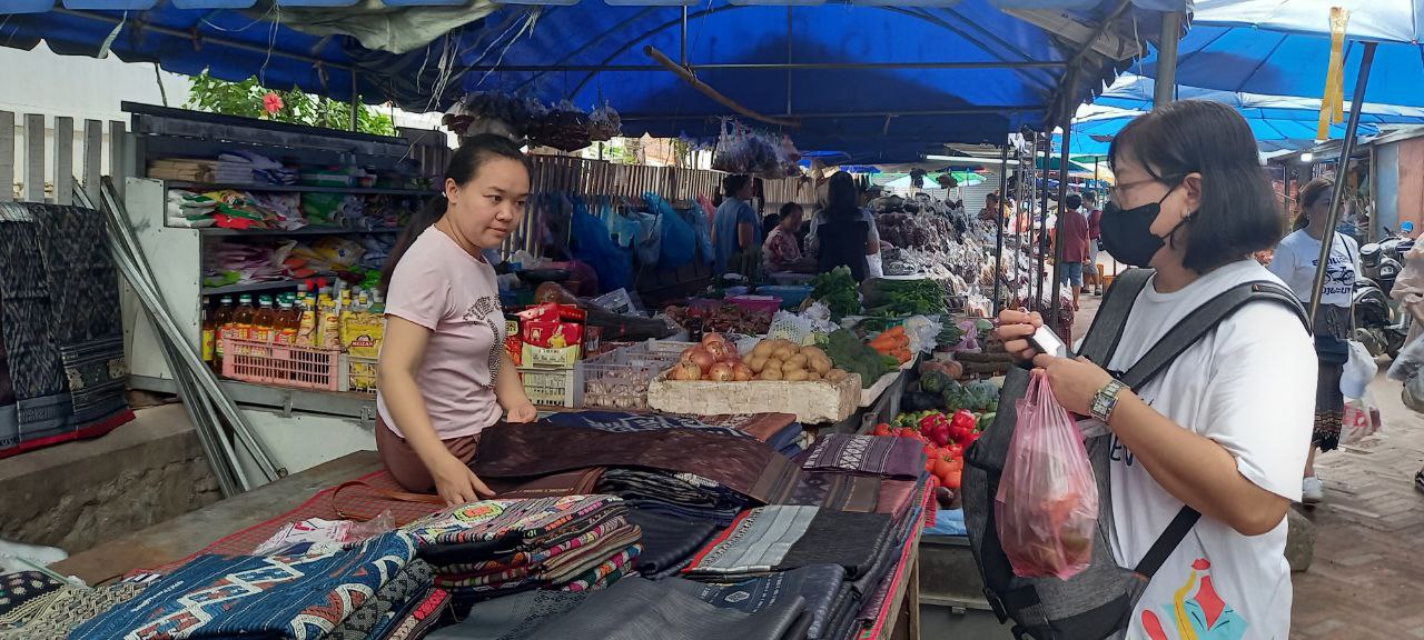 Seorang calon pembeli kain tenun khas Laos ( Foto: Daniel Otto/Vibizmedia)