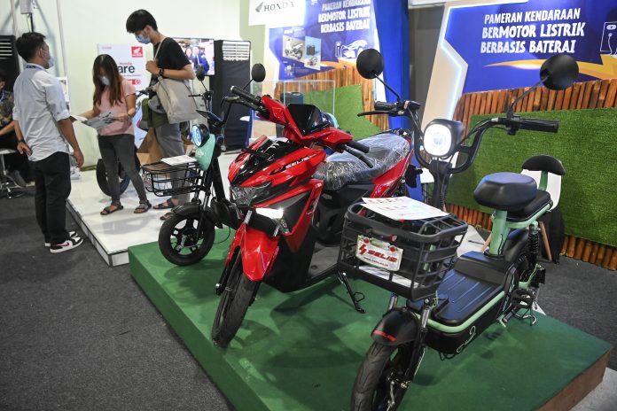 Petugas memberikan penjelasan kepada pengunjung terkait sepeda motor listrik pada Pameran Kendaraan Listrik Berbasis Baterai dalam rangkaian KTT G20 di Bali Collection, Nusa Dua, Bali, Sabtu (12/11/2022).