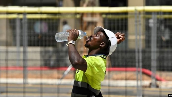 Seorang pekerja konstruksi sedang minum ditengah udara panas di Barcelona pada 18 Juli 2023. Para ilmuwan Uni Eropa mengatakan Oktober merupakan bulan terpanas yang pernah tercatat. (Foto AFP)