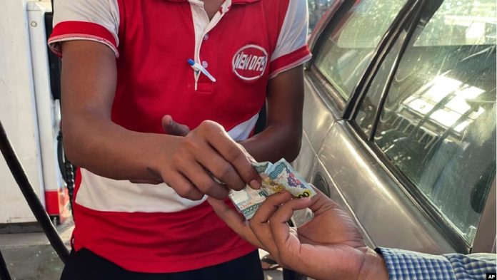 Ilustrasi Seorang pengendara menyerahkan lembaran mata uang Myanmar kyats sebagai pembayaran di sebuah pom bensin di Botahtaung, Yangon, Myanmar (Foto voaindonesia AP)