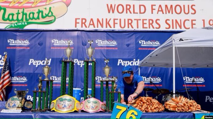 Seorang petugas menata panggung tempat perhelatan kontes makan hot dog tahunan di Coney Island di Kota New York, pada 4 Juli 2023. (Foto Reuters)