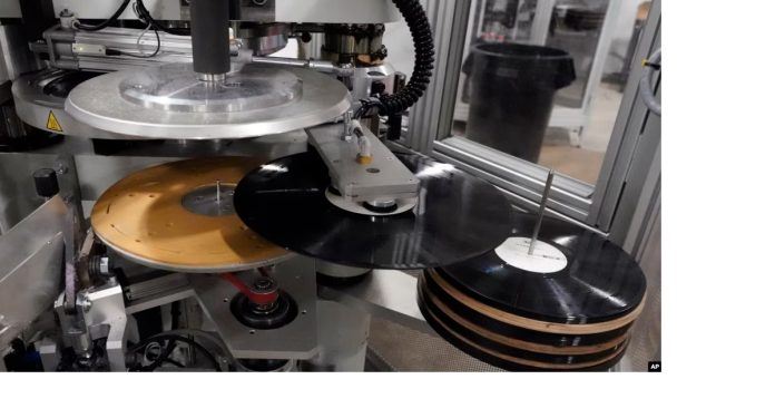Piringan hitam baru dicetak menggunakan mesin pencetak di fasilitas United Record Pressing, Nashville, Tennessee, pada Kamis, 23 Juni 2022. (Foto AP)