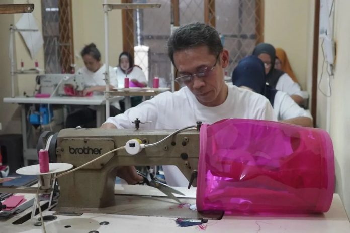 Seorang pekerja menyelesaikan proses produksi tas karakter berbentuk tabung Bright Gas 5 kg di workshop UMKM binaan Pertamina.